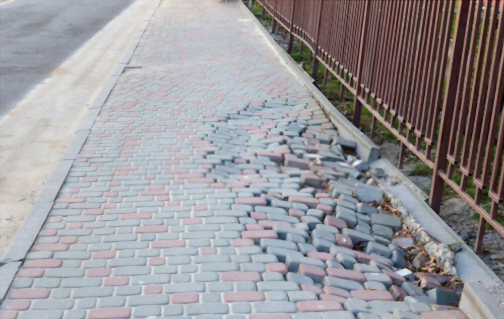 אבנים משתלבות שהתרוממו, שקעו וזזו בגלל הידוק לא מספיק של האדמה אבנים משתלבות שהתרוממו, שקעו וזזו בגלל הידוק לא מספיק של האדמה