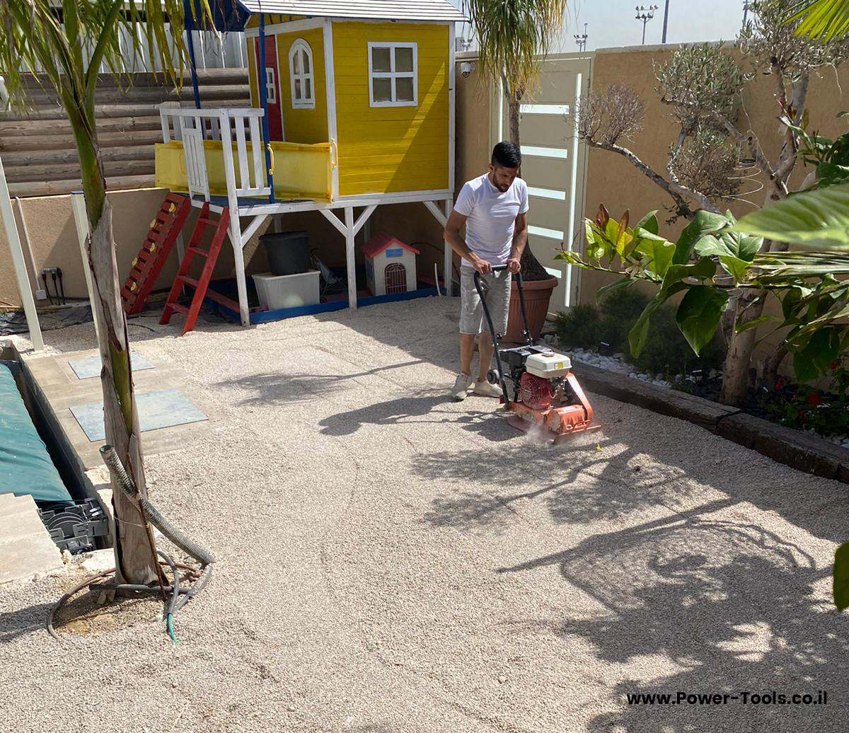 התקנת דשא סינטטי - שלב הידוק האדמה והחצץ עם מהדק אדמה התקנת דשא סינטטי - שלב הידוק האדמה והחצץ עם מהדק אדמה